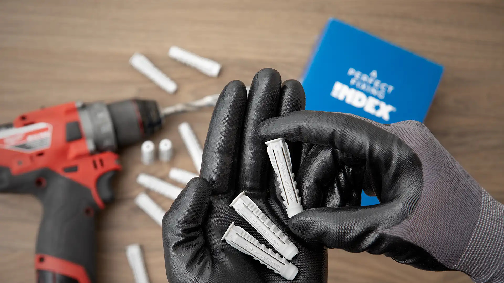 Mano de operario protegida con guante y sosteniendo caja tacos TN4S